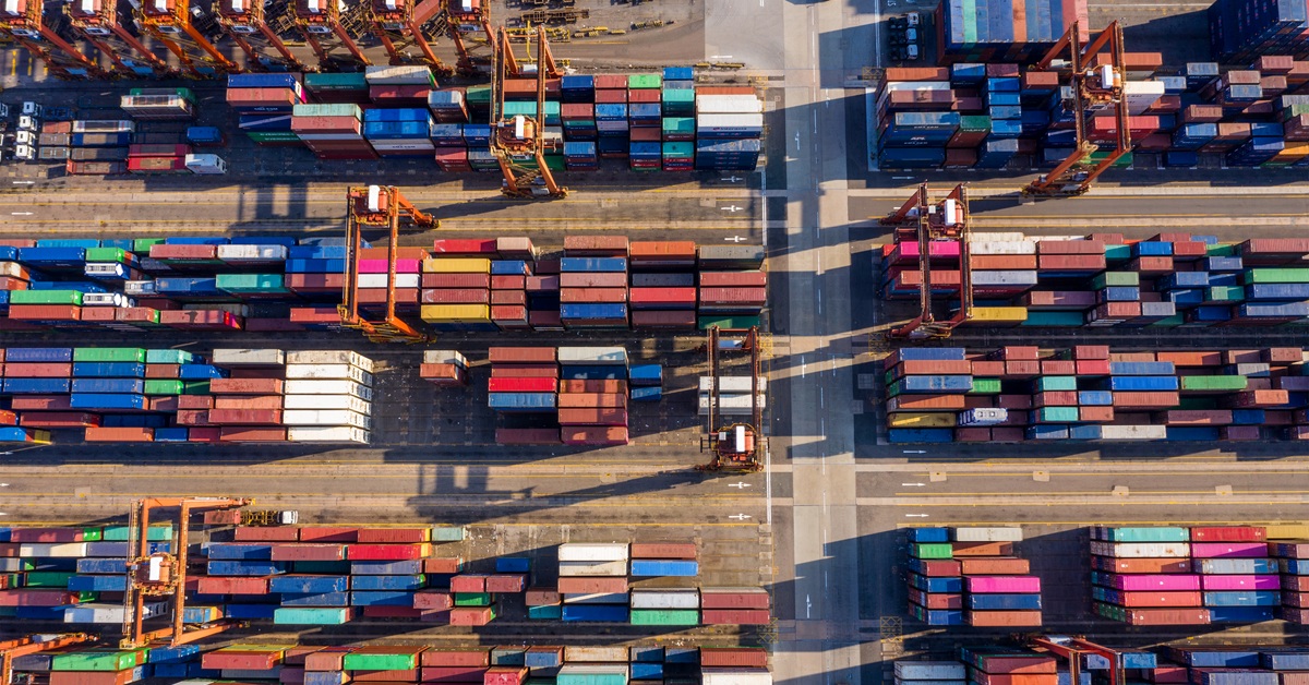Aerial view of supply chain in action, dozens of colorful shipping containers at a port